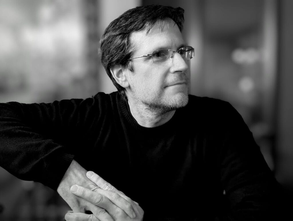 Photo noir et blanc de L.J. Montignac. Le regard ailleurs, pensif. Posture détendue